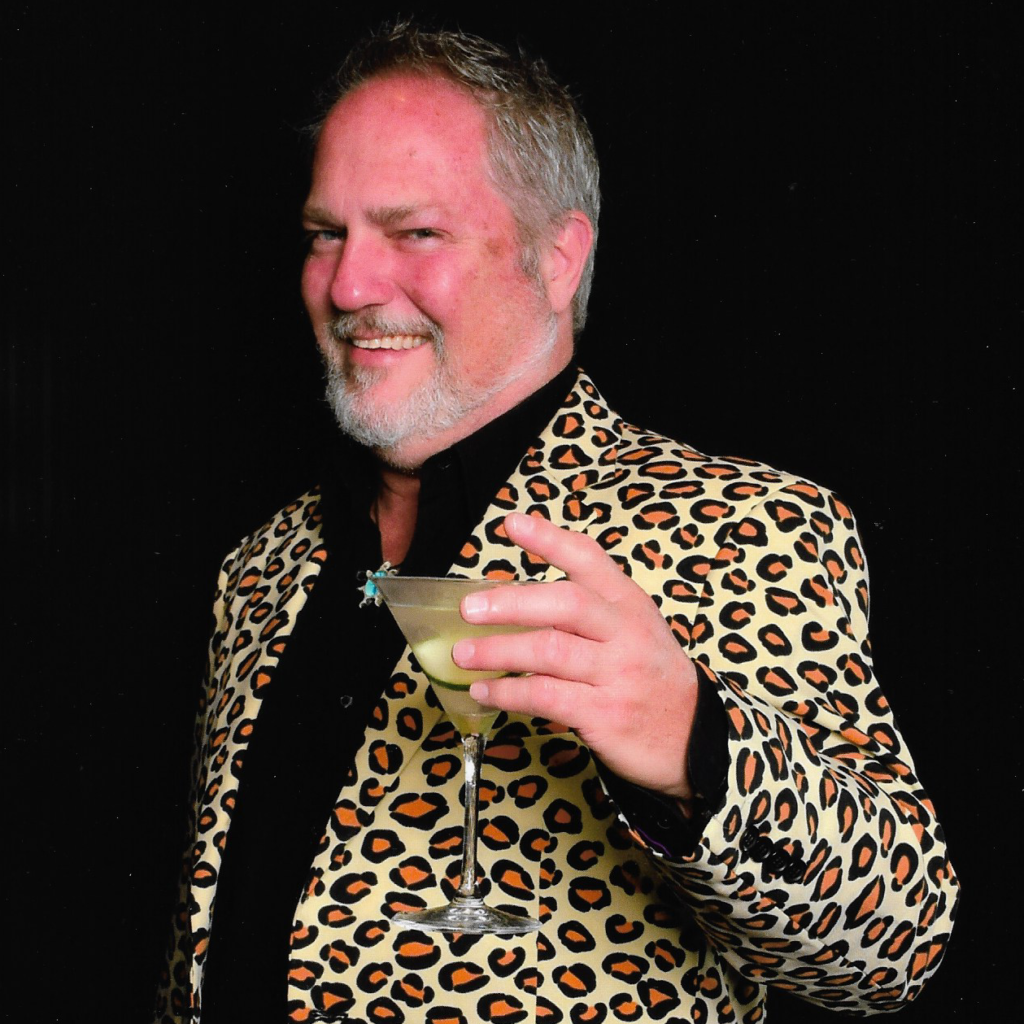 Steve Mogell, of florida frozen drinks holding martini in one of his crazy suits